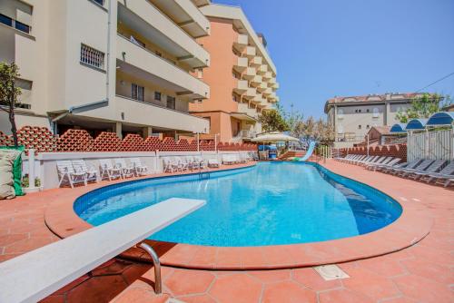 a swimming pool with a bench next to a building at Hotel Rosalba - Valentini Family Village in Bellaria-Igea Marina
