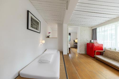 a living room with a white couch and a red refrigerator at 6號花園別墅酒店 Shenzhen No'6 Garden Villa --French Window with garden view,Close to Sea World &Shekou Ferry Port &K11 Ecoast &Subway Nearby ,Offer Western food and coffee &English speaking with tour services in Shenzhen