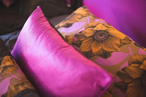 a pink pillow sitting on a bed with flowers at Riad Andalib in Fès