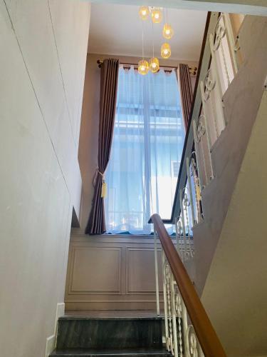 a stairway with a window and a stair case at Huang Su Villa 2 皇宿2号泳池别墅 in Nong Prue