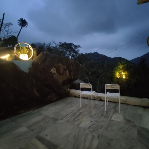 two chairs sitting on a roof at night at Valley Nest for 6-12 PAX in Mount Ābu
