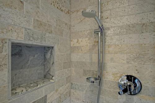a shower in a bathroom with a stone wall at Unterbergerhof in Val di Vizze