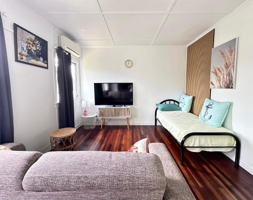 a living room with two couches and a flat screen tv at Zen Escape Guest House "Location 3" - Three listings - Hidden Gem, Funky Corner, Boutique Granny Flat in Brisbane