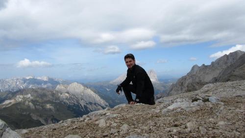 a man sitting on the top of a mountain at Hotel & Ristorante Baita Dovich in Malga Ciapela