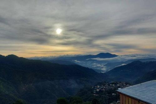 a view of a mountain valley with the sun in the sky at Ina Puring's House in Itogon