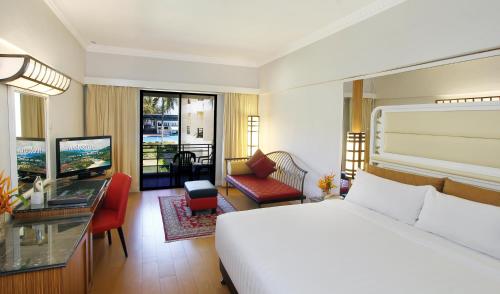 a bedroom with a bed and a living room at Holiday Villa Resort & Beachclub Langkawi in Pantai Cenang