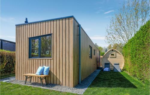 a small wooden house with a bench in a yard at Cozy Home In Heinkenszand With Kitchen in Graszode