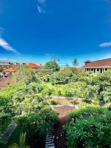 a view of a garden with trees and buildings at New Mekar Jaya Hotel in Legian