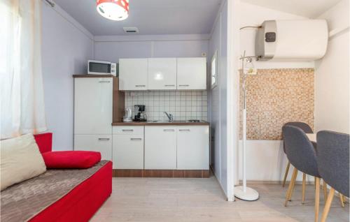 a small apartment with a red couch and a kitchen at Amazing Home In Sveti Filip I Jakov in Sveti Filip i Jakov