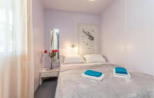 a white bedroom with a bed with two towels on it at Amazing Home In Sveti Filip I Jakov in Sveti Filip i Jakov