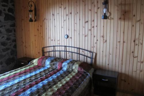 a bed in a room with a wooden wall at Villa 4 Seasons in São Roque do Pico