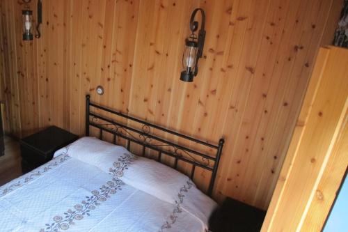 a bedroom with a bed in a wooden wall at Villa 4 Seasons in São Roque do Pico