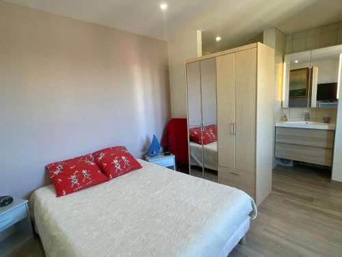 - une chambre avec un lit doté d'oreillers rouges et une salle de bains dans l'établissement Appartement 2P en bord de mer à Canet, parking inclus - FR-1-732-90, à Canet