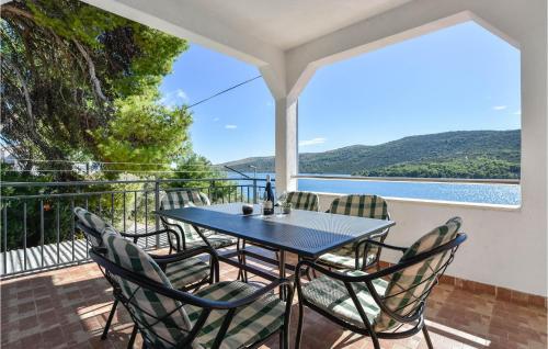ein Tisch und Stühle auf einem Balkon mit Blick auf das Wasser in der Unterkunft Holiday Home Poljicka Cesta Iii in Marina
