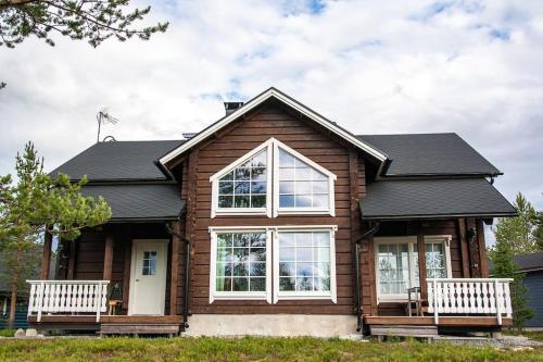 a house with two white benches in front of it at Koskikara in Äkäslompolo
