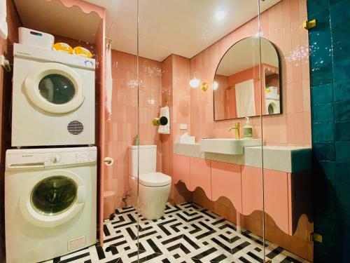 a bathroom with a washing machine and a sink at Manly Vibes - fabulous design with gym, sauna, streaming, right opposite wharf & beach in Sydney