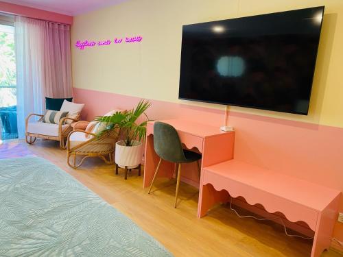 a living room with a desk and a tv on a wall at Manly Vibes - fabulous design with gym, sauna, streaming, right opposite wharf & beach in Sydney