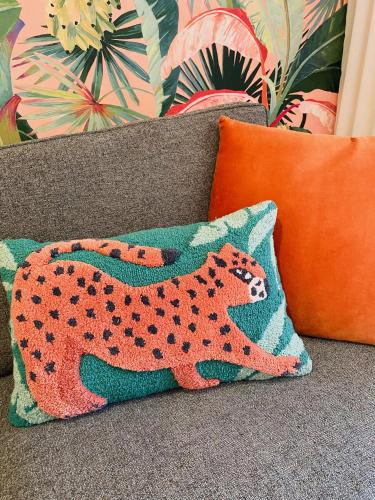 a cheetah pillow sitting on a couch at Manly Vibes - fabulous design with gym, sauna, streaming, right opposite wharf & beach in Sydney