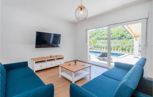 a living room with two blue couches and a table at 4 Bedroom Awesome Home In Mundanije in Mundanije