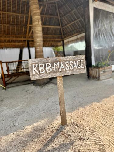 a sign that says kebasiassasy sitting in the dirt at Kiwengwa Bungalow Boutique Resort in Kiwengwa