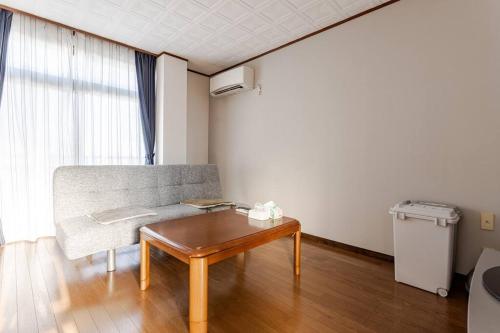 a living room with a couch and a coffee table at アンドステイ小田原堀之内194 in Odawara