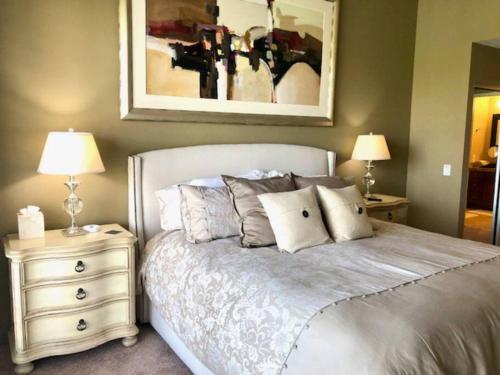 a bedroom with a bed with two night stands and two lamps at The Country Club Experience in Palm Desert