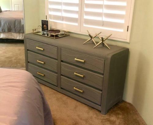 a dresser in a bedroom with a bed at The Country Club Experience in Palm Desert