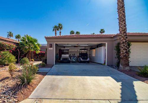 a house with a garage with two cars in it at The Country Club Experience in Palm Desert