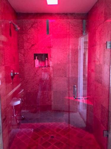 a red bathroom with a shower with a glass door at The Country Club Experience in Palm Desert