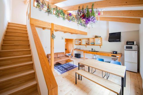 a room with stairs and a table and a kitchen at FamB in Nakafurano