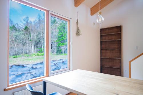 a dining room with a table and a large window at FamB in Nakafurano