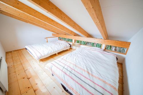 an attic bedroom with two beds and wooden floors at FamC in Nakafurano