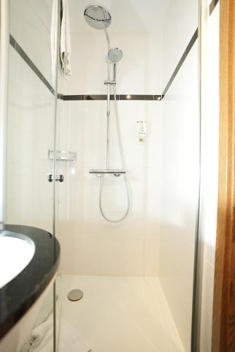 a shower with a glass door next to a sink at UNO Hotel Posthof Saarlouis in Saarlouis