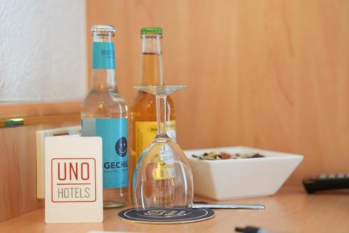 two bottles of alcohol sitting on a wooden table at UNO Hotel Posthof Saarlouis in Saarlouis