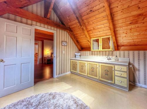 a bathroom with a sink in a room with wooden ceilings at Idyllic Retreat Swan Pond Views in Dennis