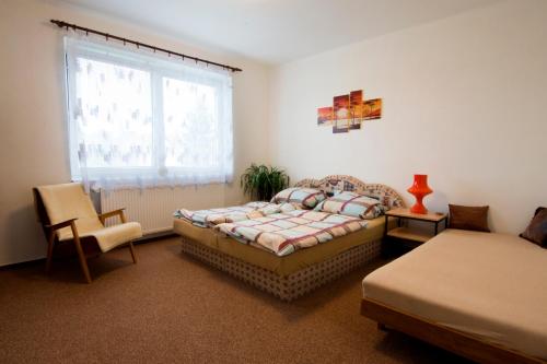 1 dormitorio con 1 cama, 1 silla y 1 ventana en Holiday Home U Čápů, en Lomnice nad Lužnicí