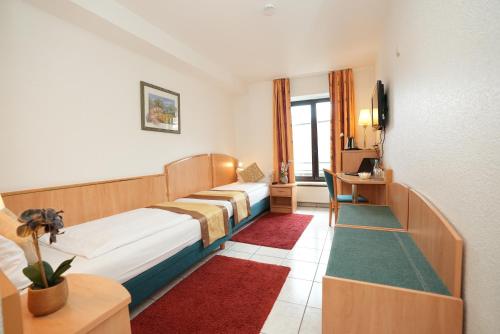 a hotel room with a bed and a tv at UNO Hotel Posthof Saarlouis in Saarlouis