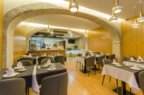 een restaurant met tafels en stoelen en een bar bij behotelisboa in Lissabon