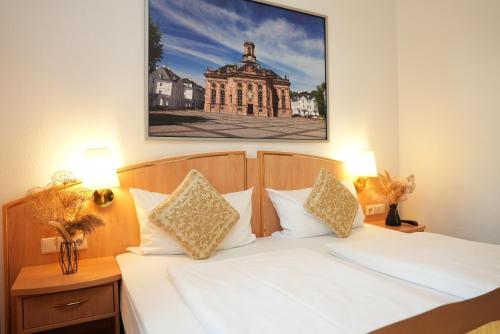 a bedroom with a white bed with a picture on the wall at UNO Hotel Posthof Saarlouis in Saarlouis