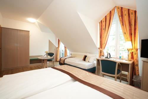 a hotel room with a bed and a desk and a room at UNO Hotel Posthof Saarlouis in Saarlouis
