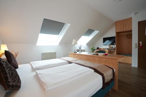 a bedroom with a large bed with two skylights at UNO Hotel Posthof Saarlouis in Saarlouis