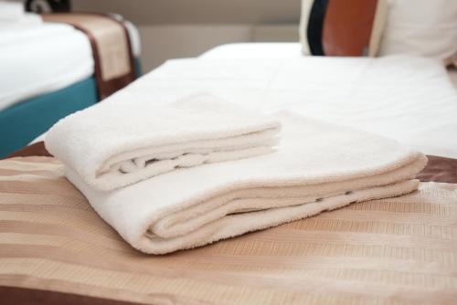 a stack of towels sitting on top of a bed at UNO Hotel Posthof Saarlouis in Saarlouis