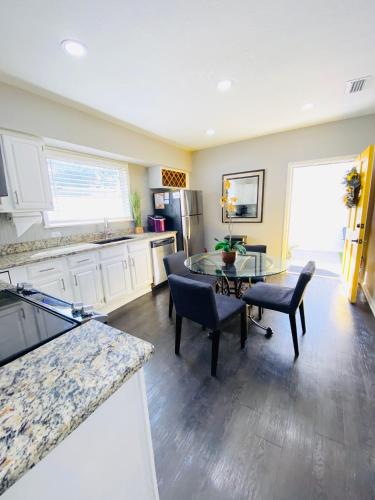 a kitchen with a table and some chairs and a counter at No Ho yellow door bungalow in Tampa