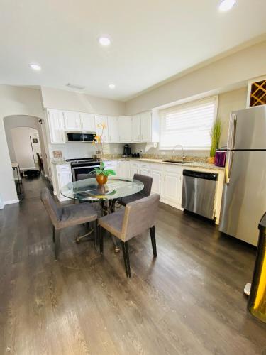a kitchen with a table and chairs and a refrigerator at No Ho yellow door bungalow in Tampa