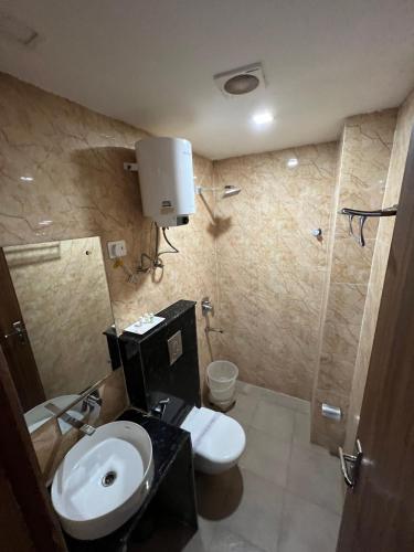 a bathroom with a sink and a toilet and a shower at Hotel Royal Inn igi in New Delhi
