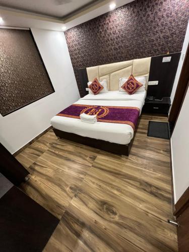 a bedroom with a bed and a wooden floor at Hotel Royal Inn igi in New Delhi
