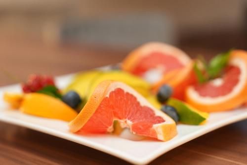 a plate of fruit on a wooden table at UNO Hotel Posthof Saarlouis in Saarlouis
