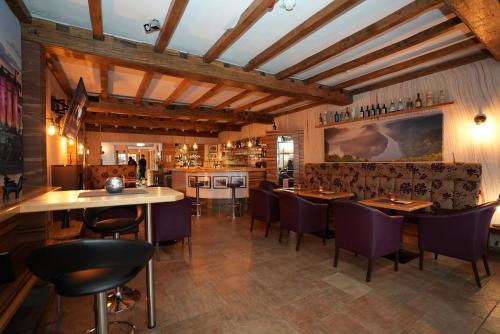 a restaurant with wooden ceilings and tables and chairs at UNO Hotel Posthof Saarlouis in Saarlouis