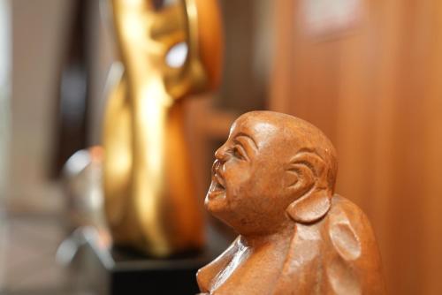 a small wooden figurine of a man on a table at UNO Hotel Posthof Saarlouis in Saarlouis