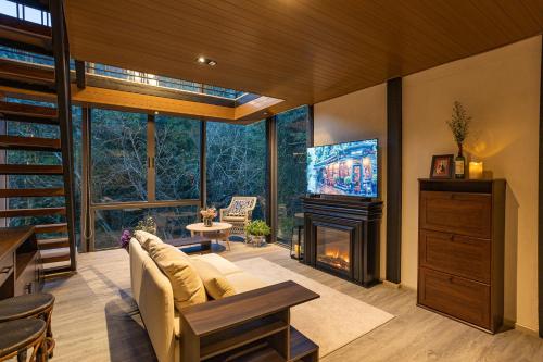 a living room with a couch and a tv and a fireplace at The Stream House in Ban Pok Nai